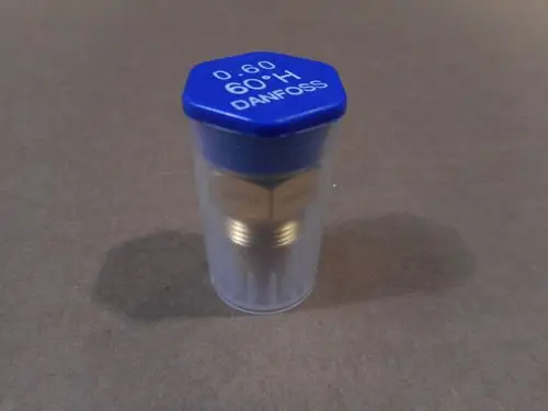 Transparente Verpackung mit einer Düse von Remeha. Der obere Teil ist blau mit weißen Schriftzügen; die Düse selbst hat goldene Metallkomponenten.
